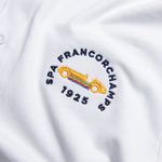 Formula 1 fans: This is a detail shot of a white polo shirt front embroidered with navy Spa-Francorchamps name, orange vintage Grand Prix car plus navy 1925.